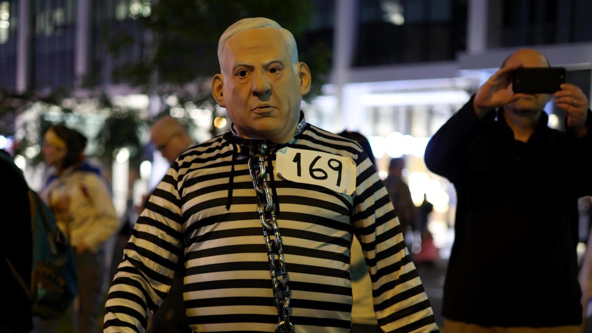 Un manifestante vestido con uniforme de preso y con una máscara de Benjamin Netanyahu participa en una protesta contra el Gobierno del primer ministro israelí