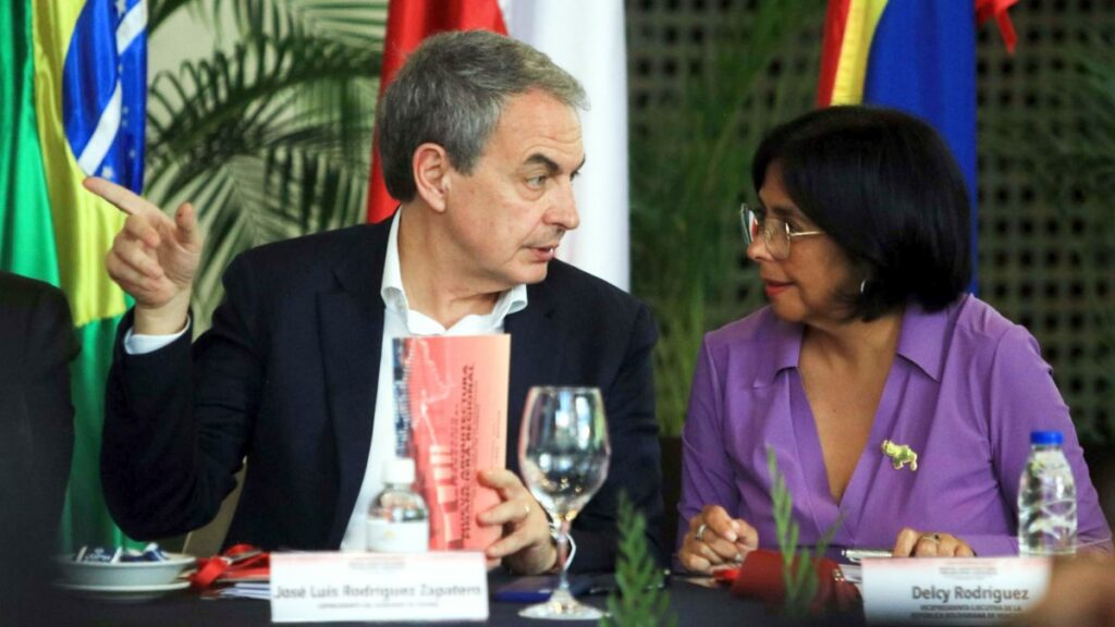 El expresidente de España, José Luis Rodríguez Zapatero, habla con la vicepresidenta de Venezuela, Delcy Rodríguez