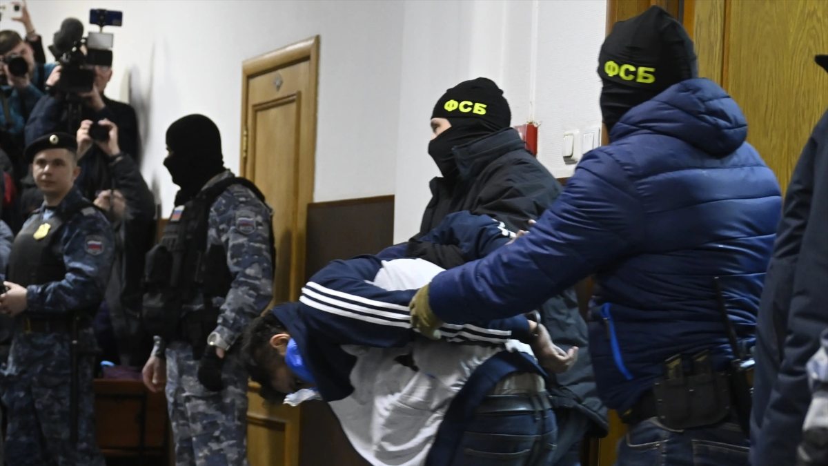 Agentes del Servicio Federal de Seguridad de Rusia con uno de los sospechosos del atentado de Moscú