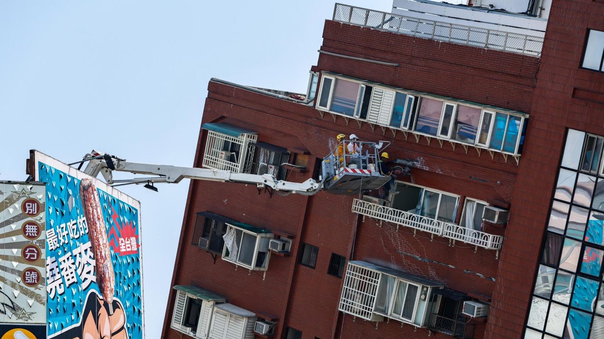 El personal del Gobierno inspecciona el exterior de un edificio residencial parcialmente derrumbado tras el terremoto en Taiwán