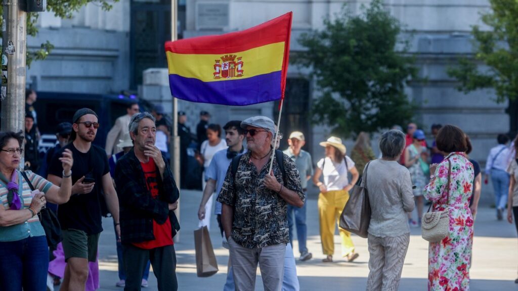 Una de las personas que acudió a la marcha contra la monarquía porta una bandera republicana.