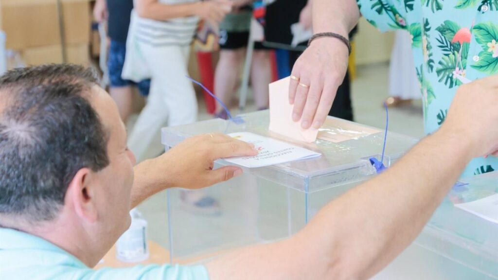 Una mujer deposita su voto en un colegio electoral
