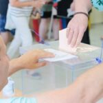 Una mujer deposita su voto en un colegio electoral