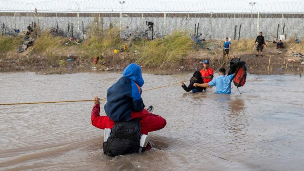 Migrantes usan una cuerda para atravesar el profundo Río Grande mientras cruzan la frontera desde Ciudad Juárez, Chihuahua, México hacia Estados Unidos.
