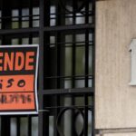 Vista de un cartel de 'Se vende' en un portal de un edificio.