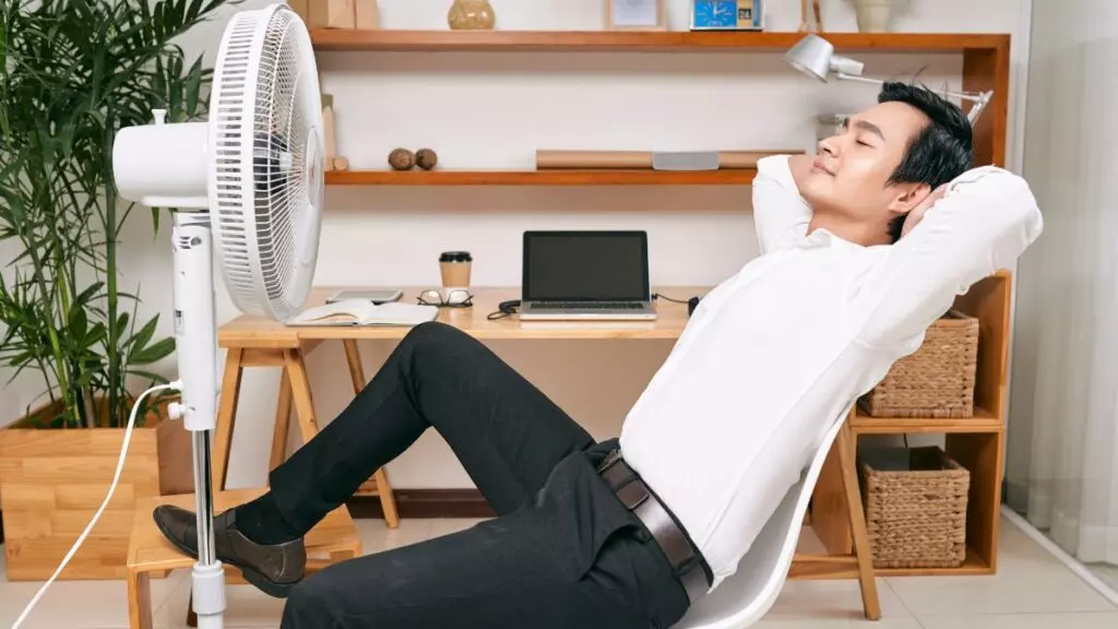 Un hombre usando un ventilador.