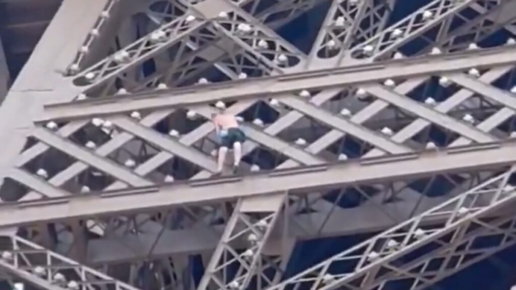 Un hombre escalta la Torre Eiffel hora antes de la clausura de los Juegos Olímpicos.