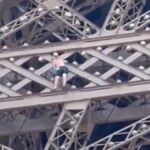 Un hombre escalta la Torre Eiffel hora antes de la clausura de los Juegos Olímpicos.