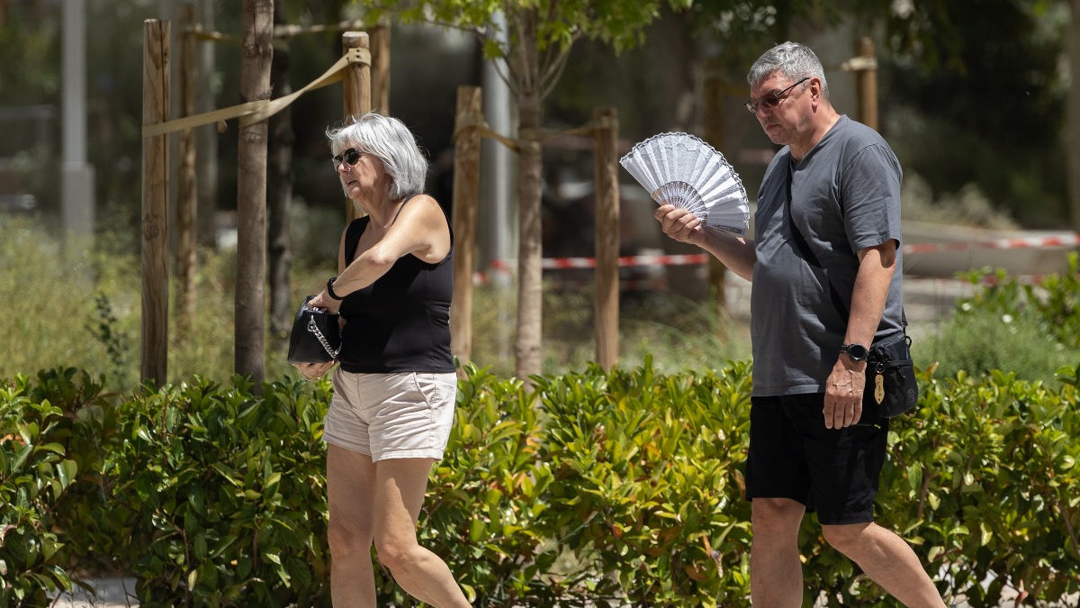 Dos personas sufriendo el calor mientras pasean por Madrid