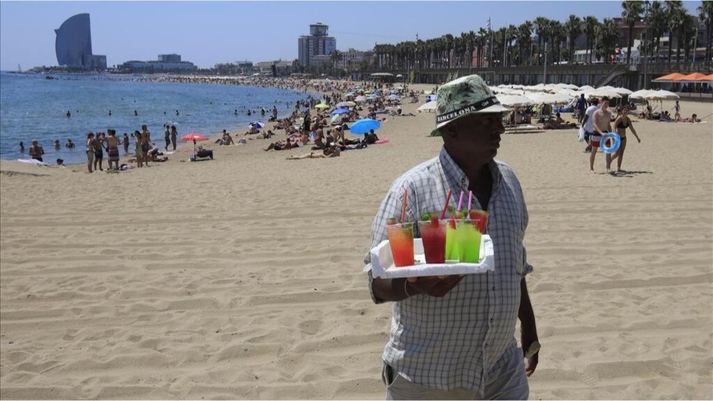 Vendedores ambulantes vendiendo mojitos en la playa de la Barceloneta.