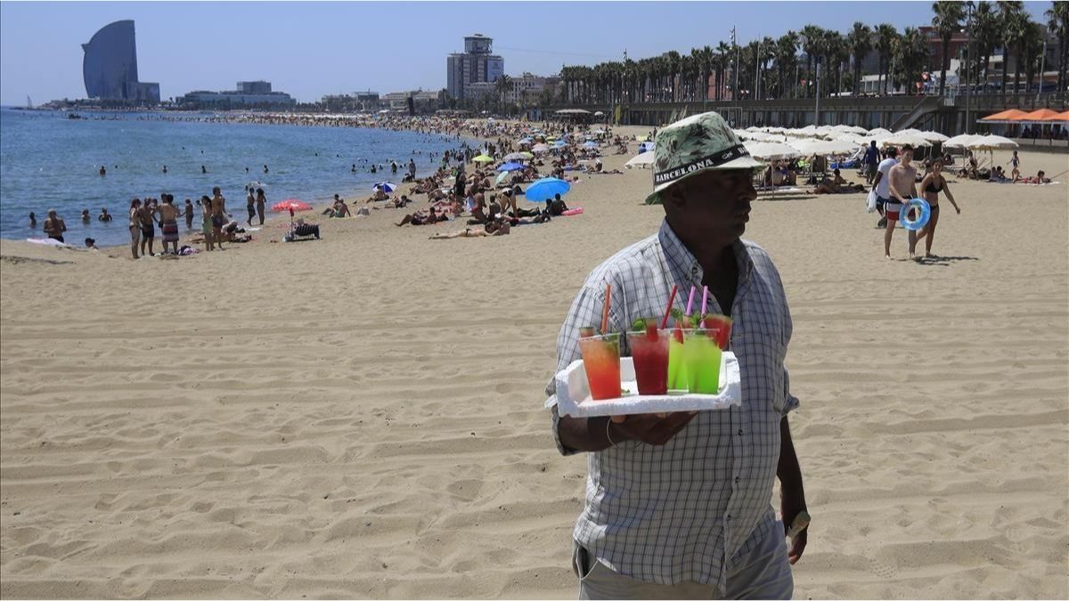 Vendedores ambulantes vendiendo mojitos en la playa de la Barceloneta.