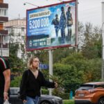 Calle de Moscú con un cartel animando a alistarse en el Ejército