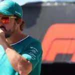 Fernando Alonso, piloto de Aston Martin, bebiendo agua antes de un Gran Premio de Fórmula 1.