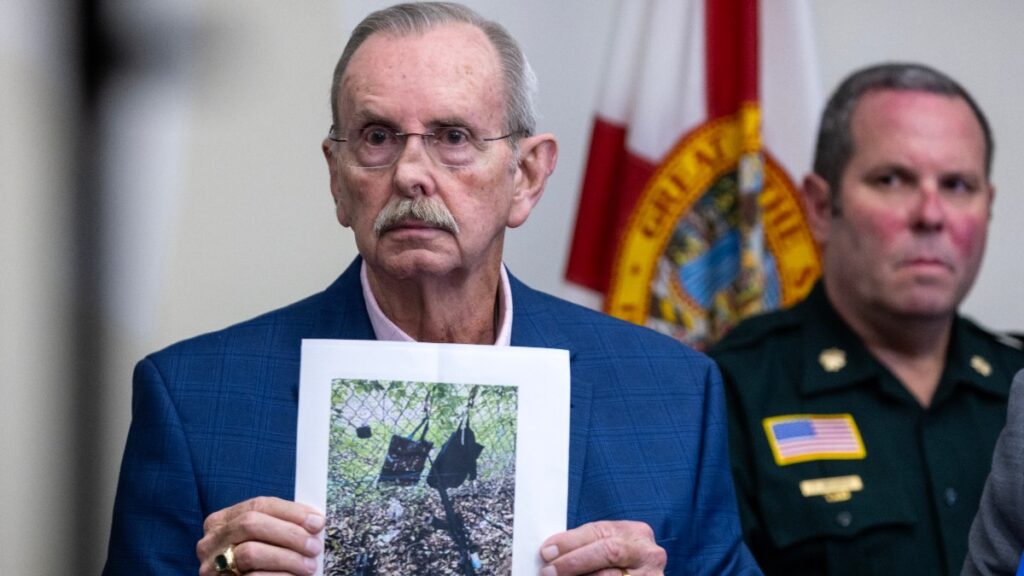 Sheriff Bradshaw mostrando una imagen del rifle usado en el intento de asesinato