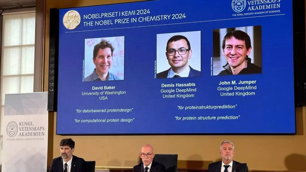 Imágenes de David Baker, Demis Hassabis y John M. Jumper se muestran en la pantalla durante la conferencia de prensa en la que se anuncia el Premio Nobel de Química 2024